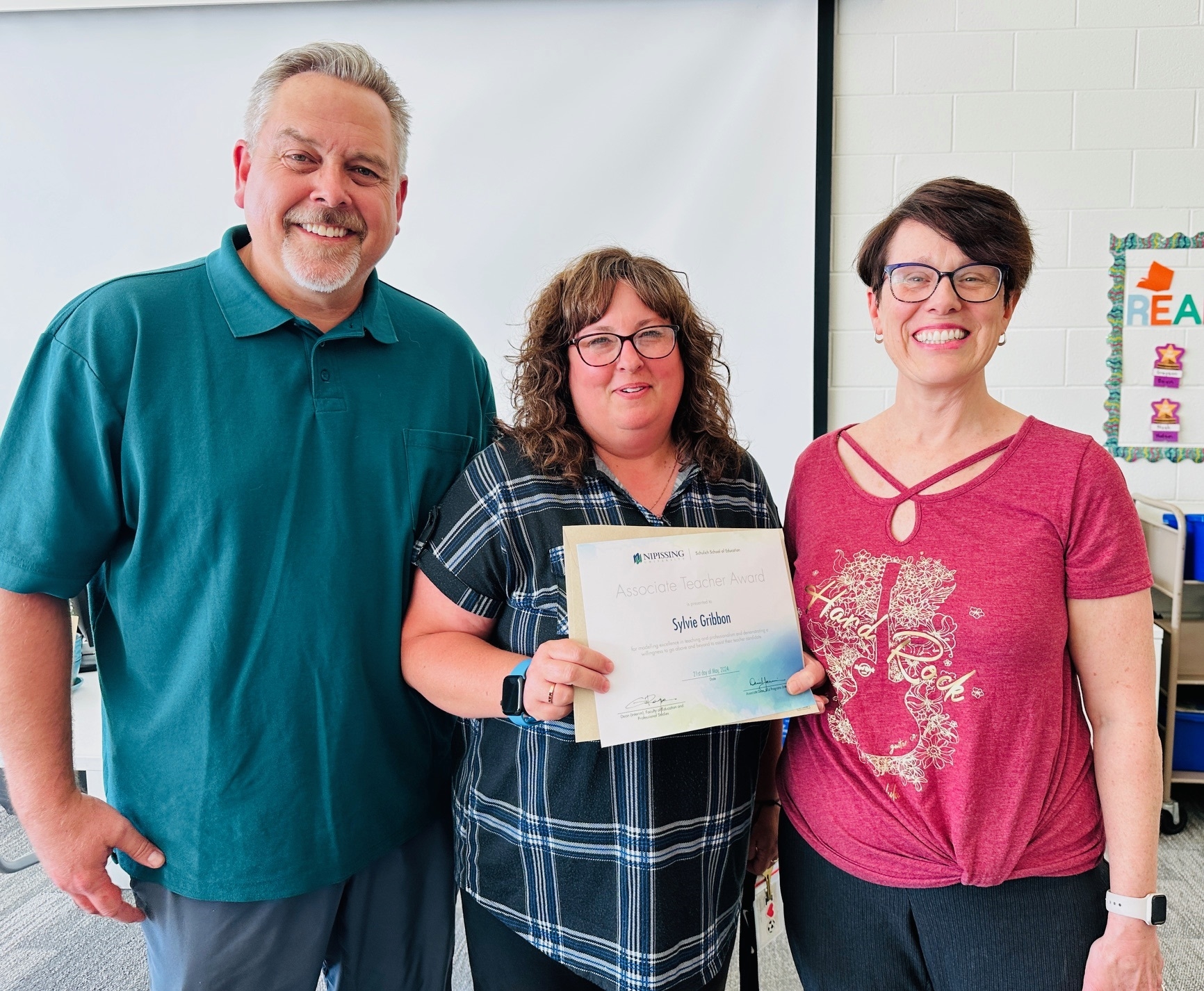 An award winner holding her award certificate with the Office Dean and Practicum Officer