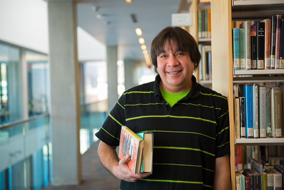 Indigenous man poses for photo at the library.