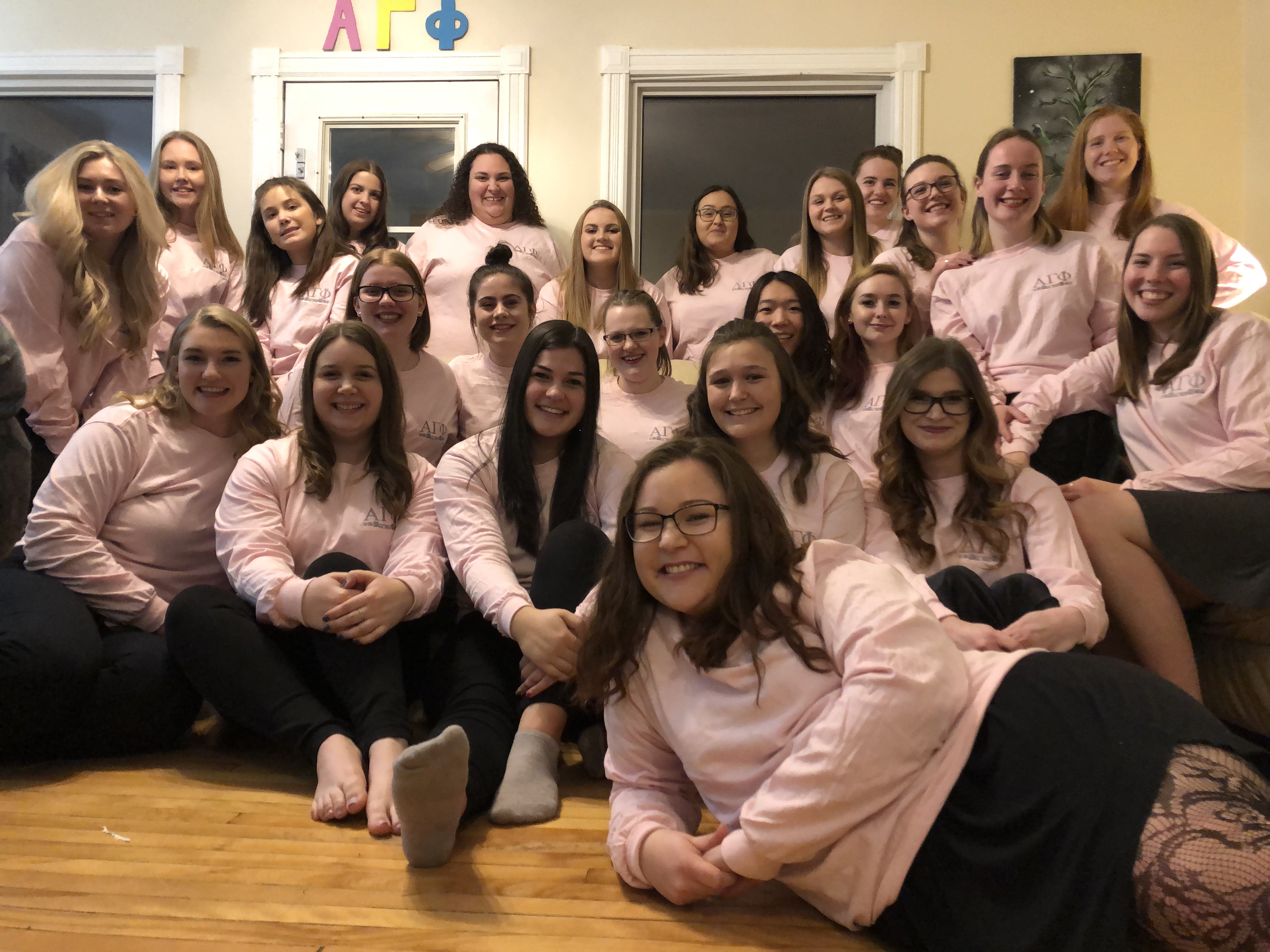 Group photo of students in Alpha Gamma Phi. All wearing pink sorority shirts. 