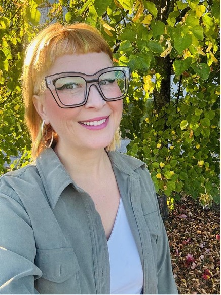 A woman taking a selfie in front of a nature background