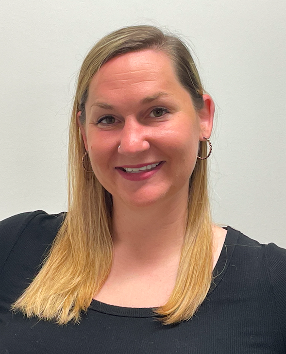 A woman with shoulder length blonde hair in a black top against a white background