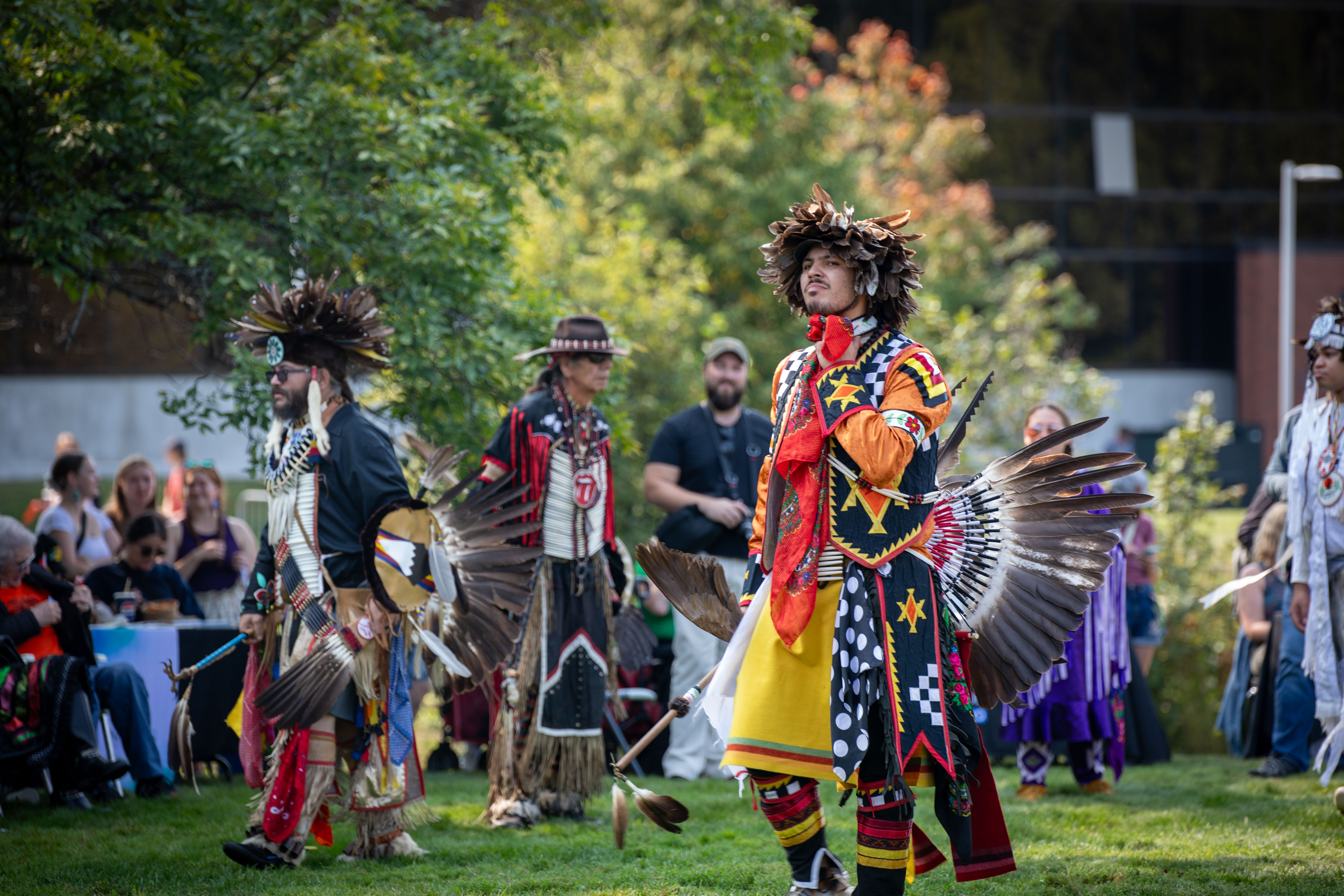 Pow wow dancer and attendees enjoying the campus event.