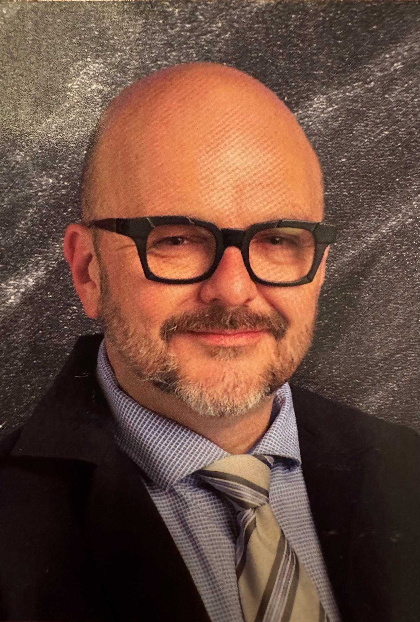 Shawn Darby from the shoulder up in front of a grey textured background