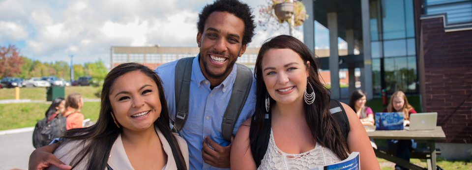three students outside of library