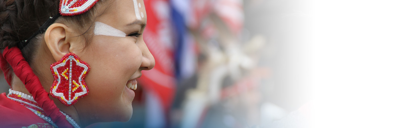 Close up image of an Indigenous woman wearing red beaded earrings