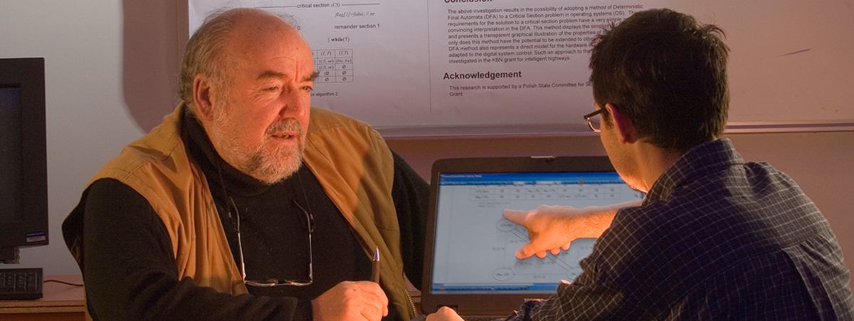 a professor helping a student on a computer