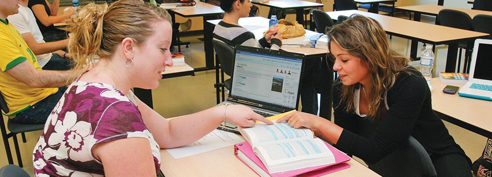 a professor helping a student in an economics class