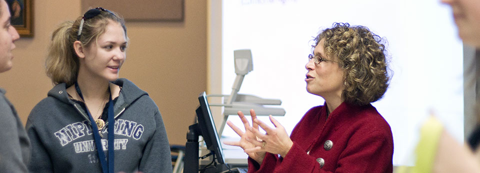 a professor talking with two students