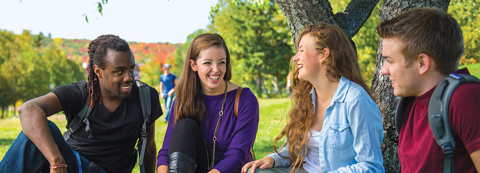 four students sitting outside