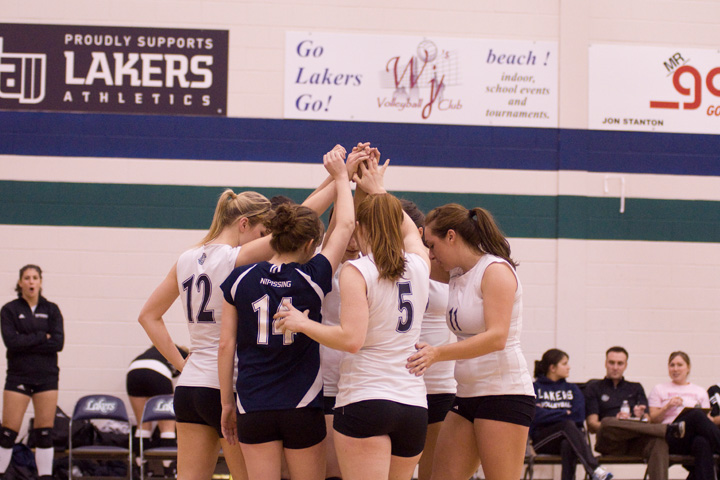 Group of student athletes huddle together during a game.