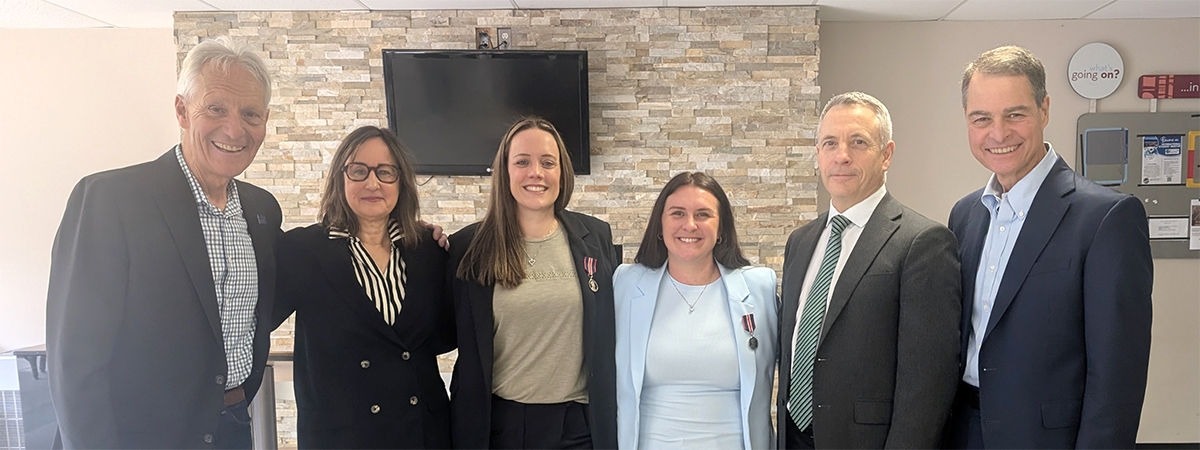 recipients Paige and Macrina stand with local officials after receiving their medals