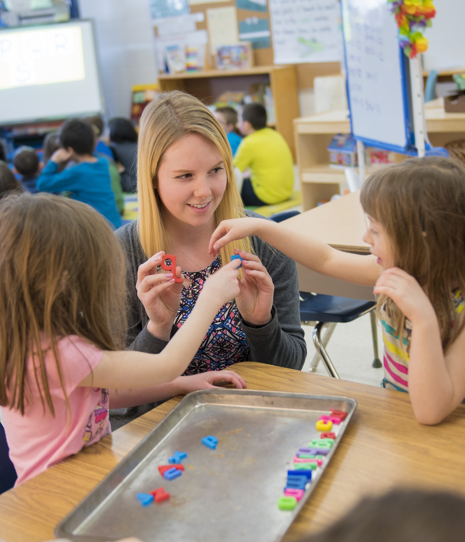 A teacher playing with some students in a classroom setting