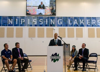 Photo of Chris Cheng at the podium in the gym