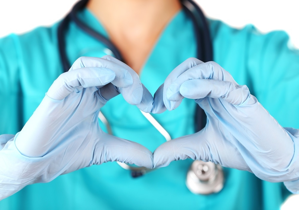 Photo of healthcare professional making a heart symbol with their gloved hands