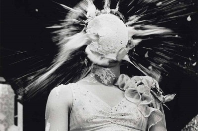 Black and white photo of a woman getting a pie in the face