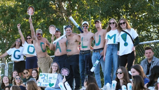 Lakers cheering with painted letters that spell "GO CALLUM!"