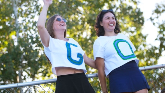 Two Lakers cheering on, shirts spell "GO"