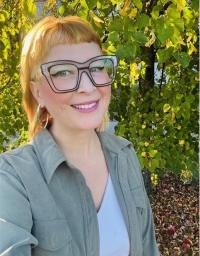 A woman taking a selfie in front of a nature background