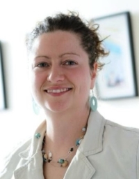 A woman in white top against a light interior background