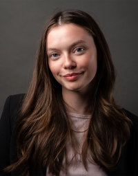 A woman in black top against a dark grey background