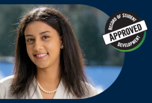 Priya smiling into the camera with a snowy background 