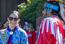 two pow wow participants donning Indigenous regalia.