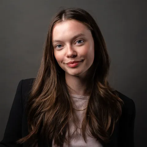 A woman in black top against a dark grey background