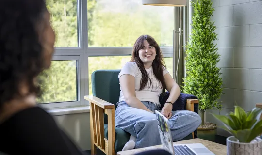 Two NU students socializing in residence living room 