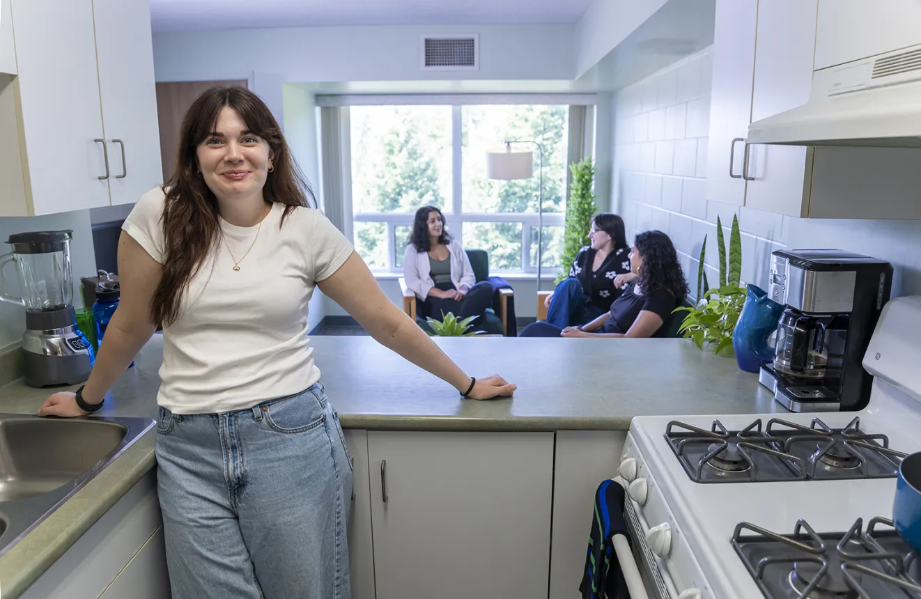 An NU student is standing in the residence kitchen 