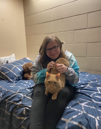 Breanna and April sit on her bed together in their NU residence room.